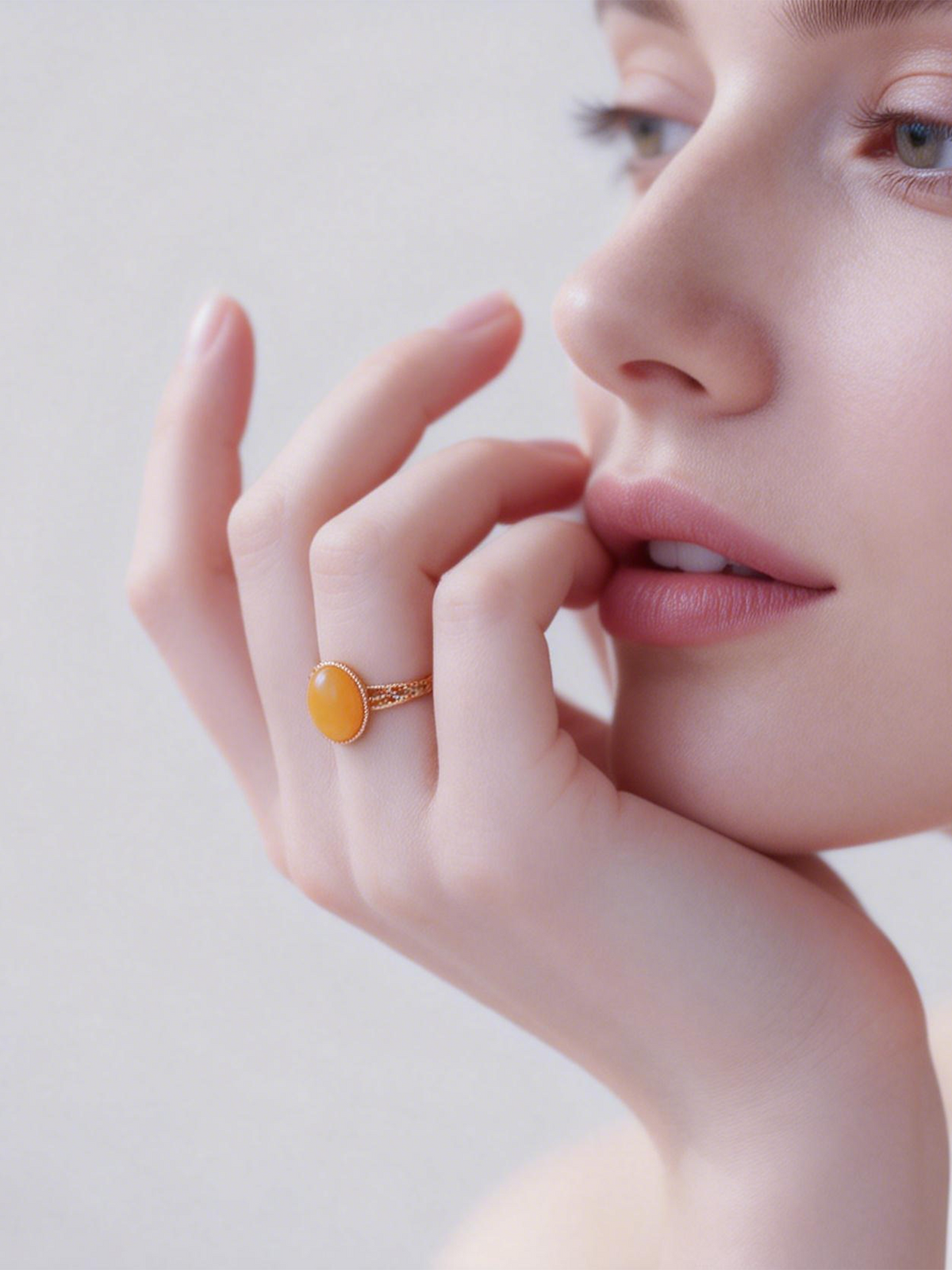 Model wearing the Lattice Filigree amber ring near her face