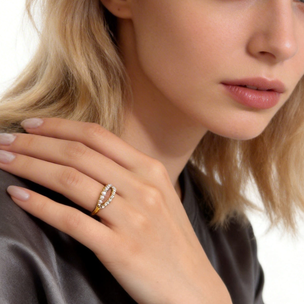 Gold double-row sparkle ring worn with the model's hand near her face