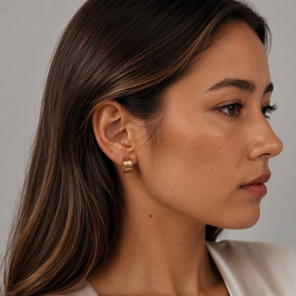Model wearing SOMIY Ribbed Column Clip-On Hoop Earrings in gold