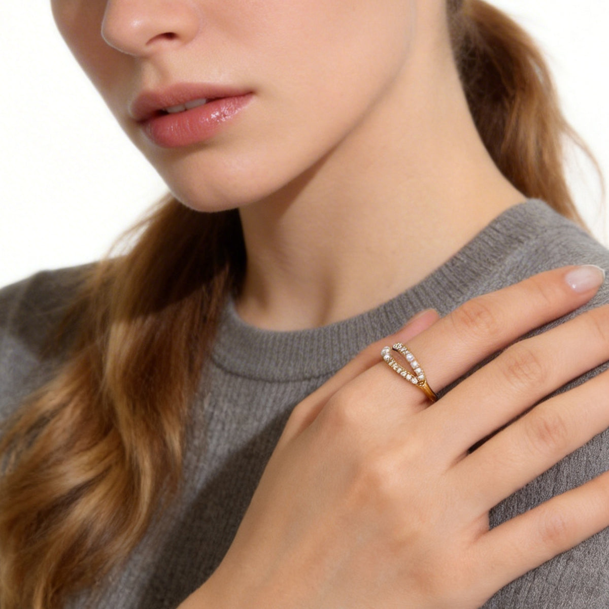 Close view of a gold double-row ring worn with a hand at the neck