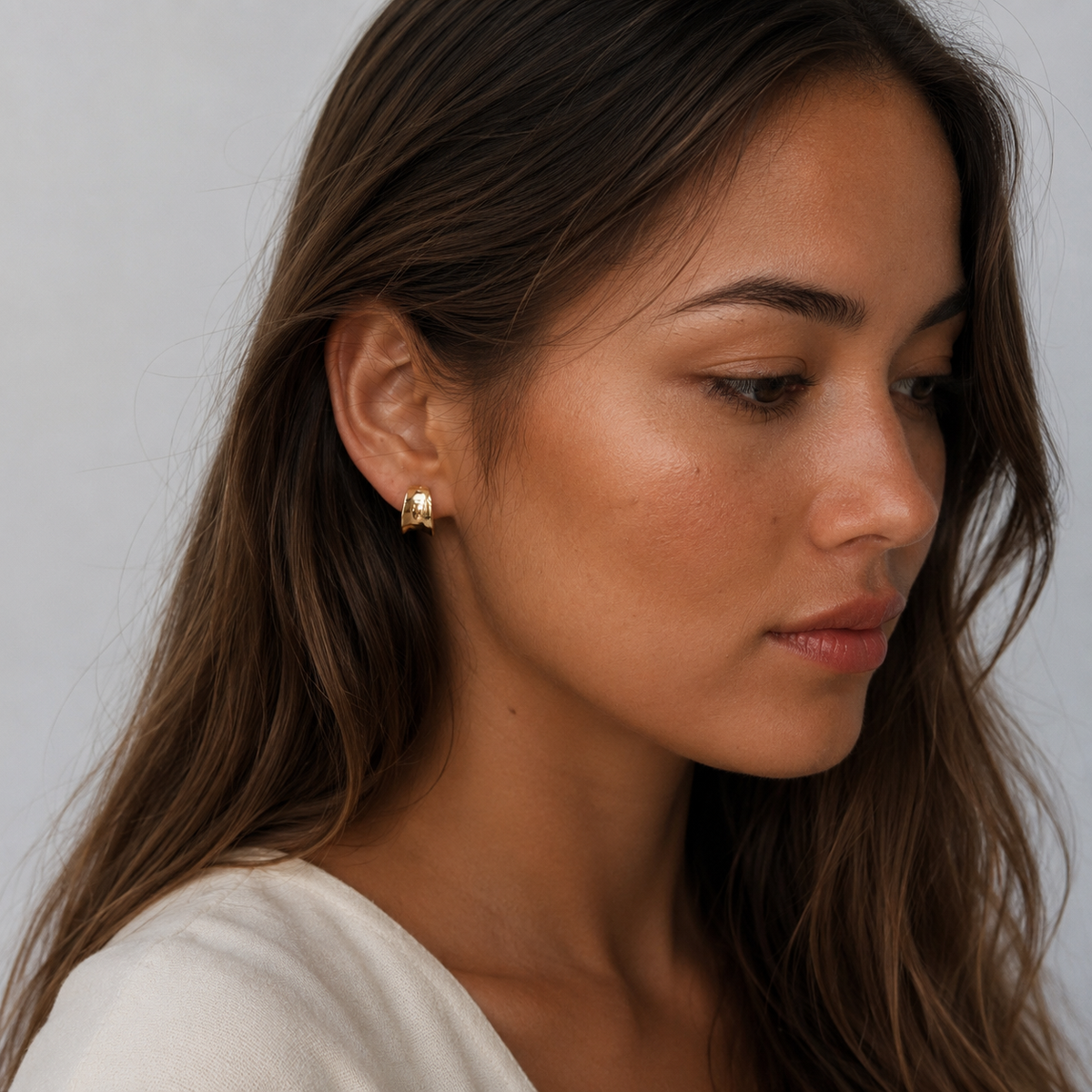 Model wearing SOMIY Mini Chunky Polished Clip-On Hoop Earrings in gold