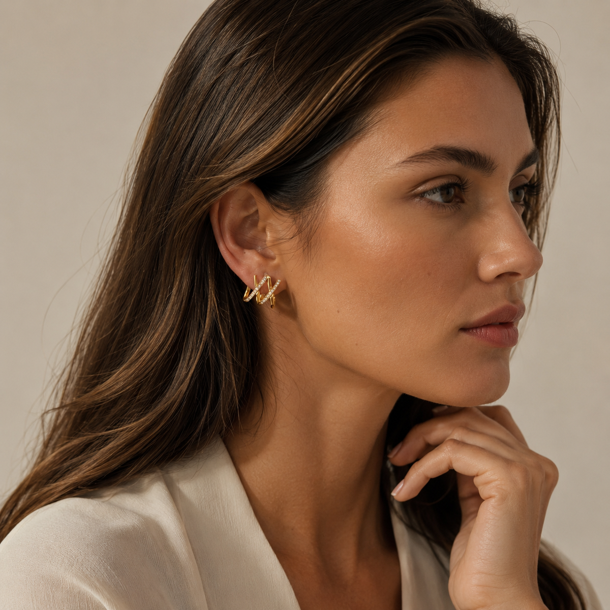 Model wearing SOMIY Crystal Wave Clip-On Hoop Earrings in gold