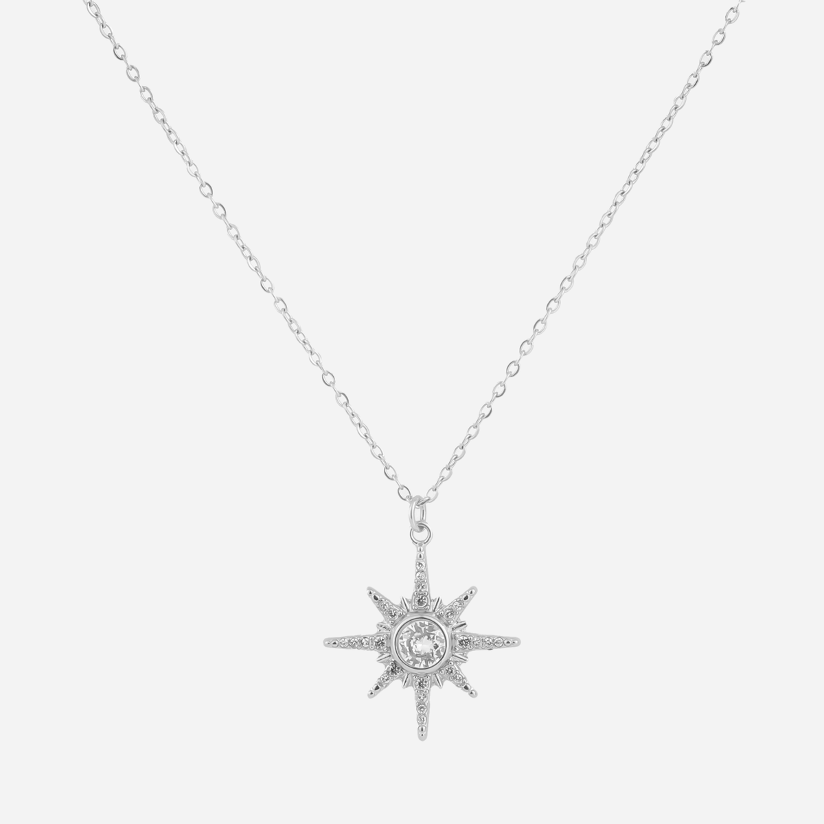 Silver eight-point starburst pendant necklace with a clear center stone