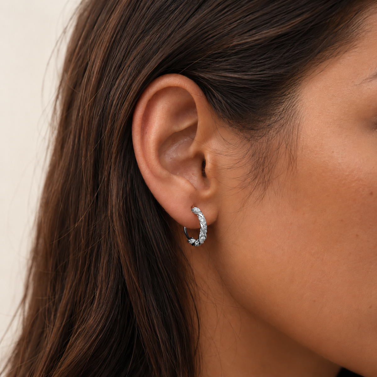 Close-up of SOMIY Möbius Sparkle Clip-On Hoop Earrings in silver worn on the ear