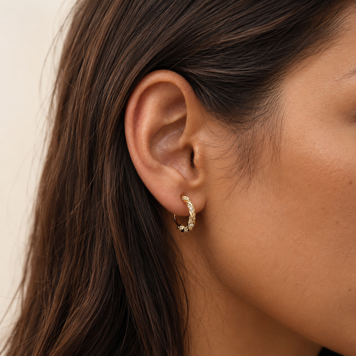 Close-up of SOMIY Möbius Sparkle Clip-On Hoop Earrings in gold worn on the ear