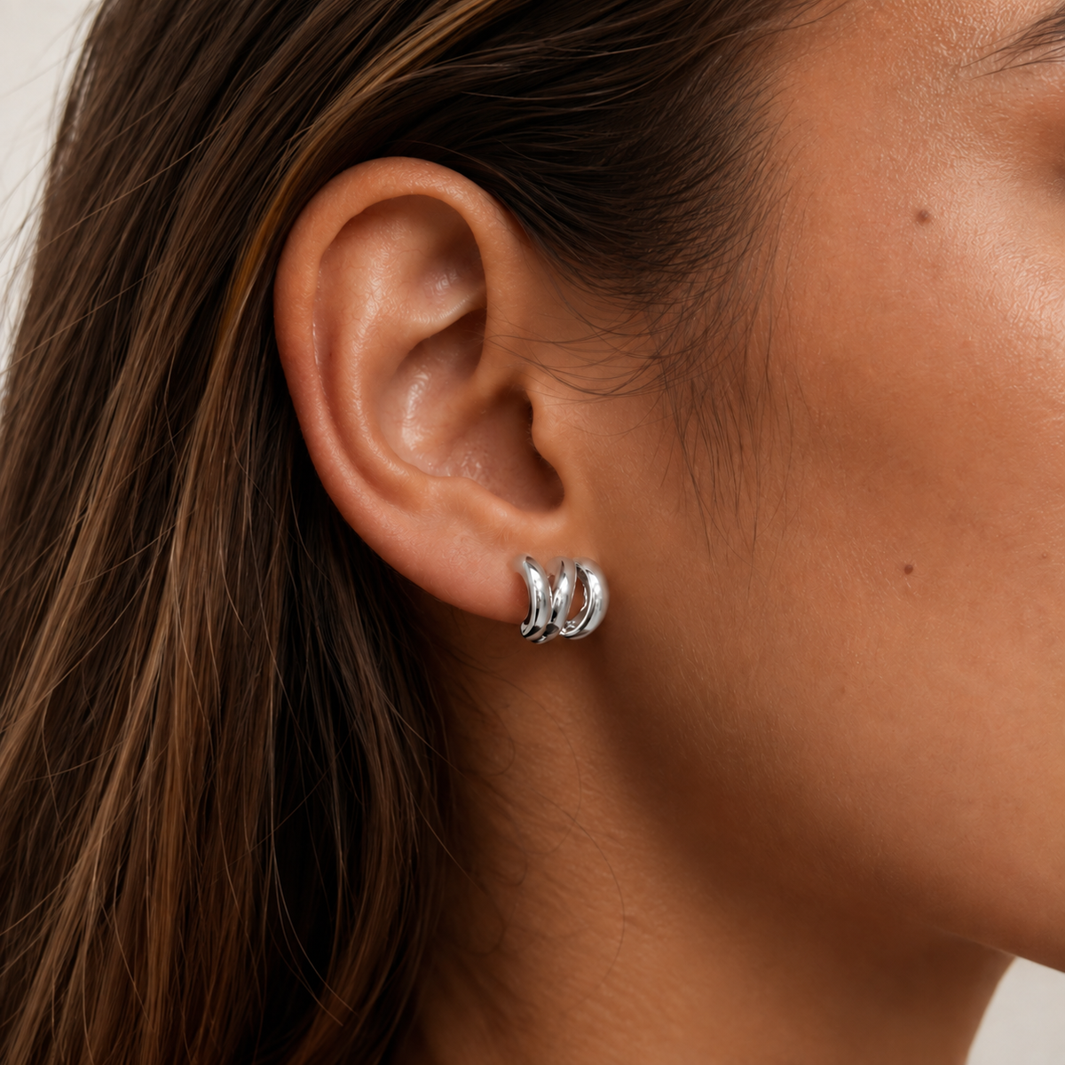 Close-up of SOMIY Geometric Irregular Triple Hoop Clip-On Earrings in silver worn on the ear
