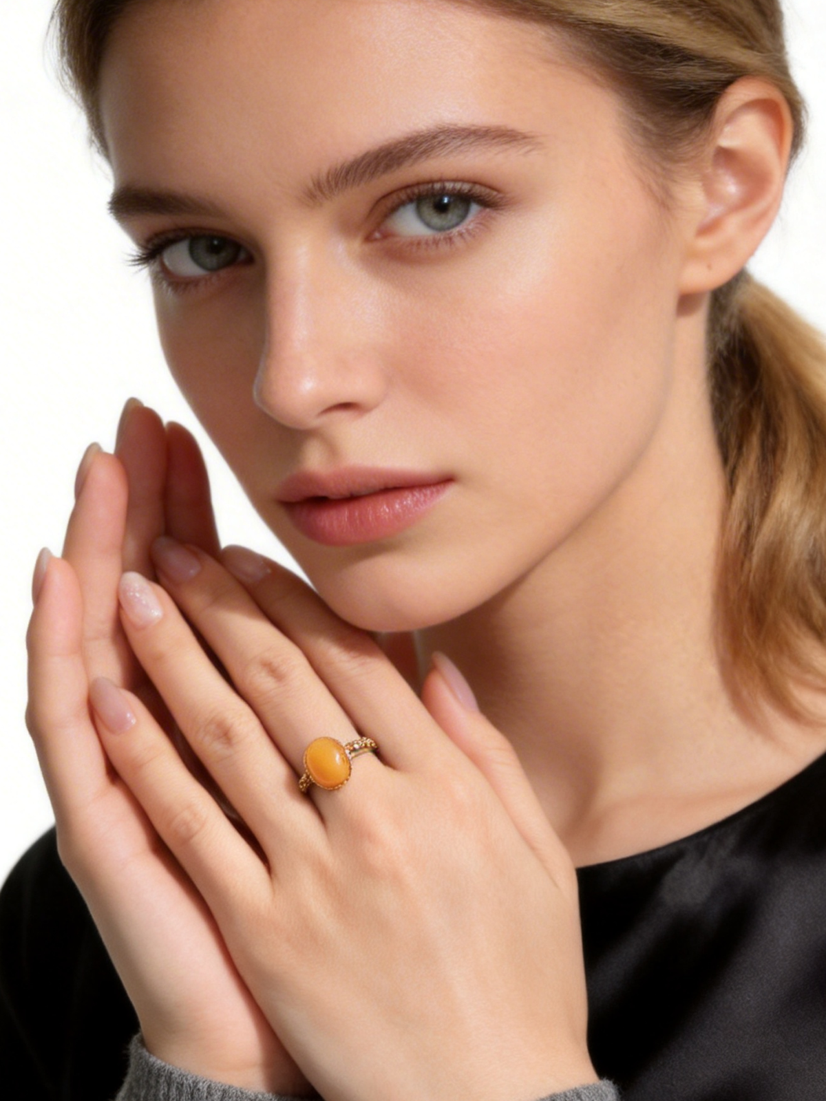 Verdant Vine amber ring worn with a black top in a close portrait