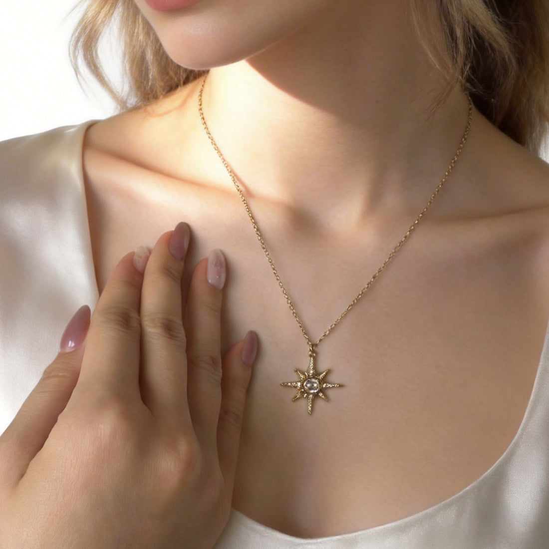 Gold eight-point starburst pendant necklace with a clear center stone