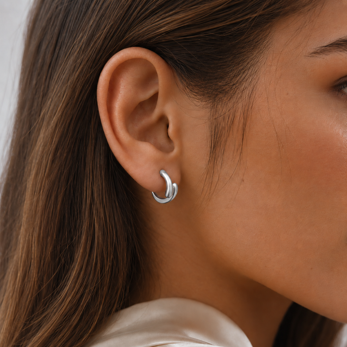 Close-up of SOMIY Geometric Teardrop Clip-On Earrings in silver worn on the ear