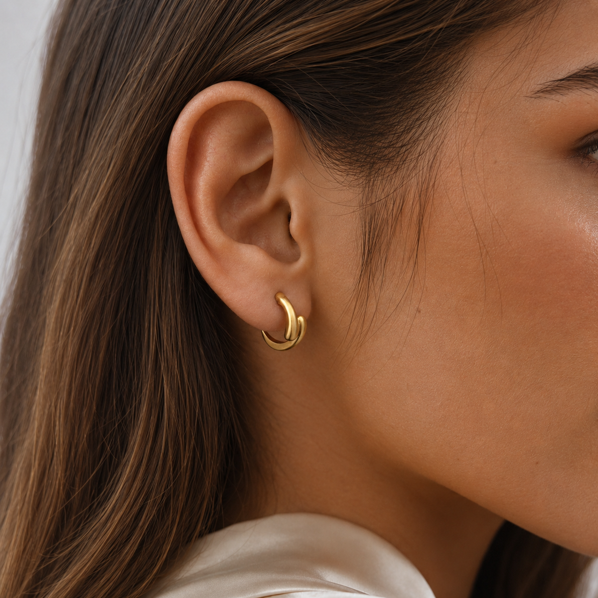 Close-up of SOMIY Geometric Teardrop Clip-On Earrings in gold worn on the ear