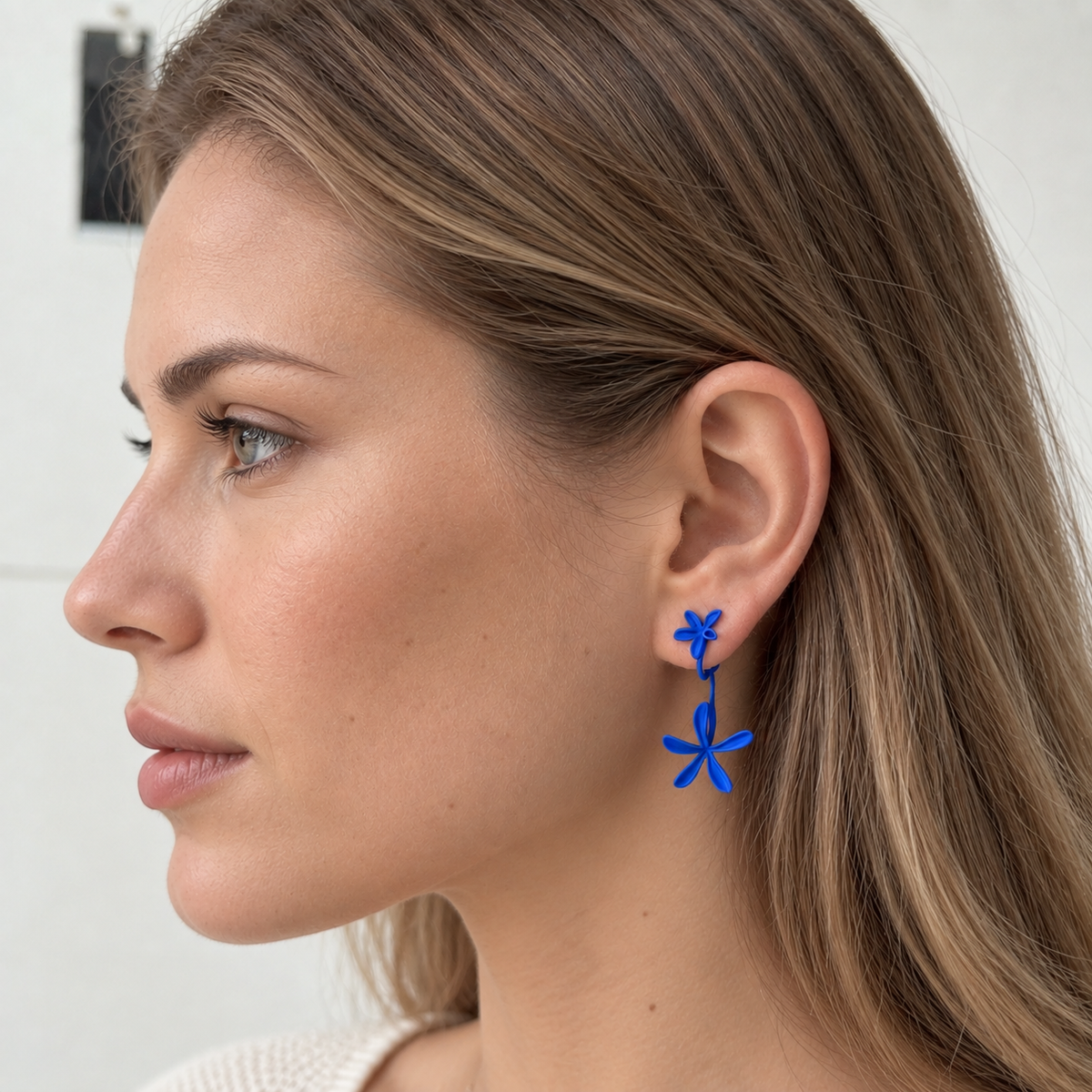 Klein blue matte flower drop earrings worn by a model