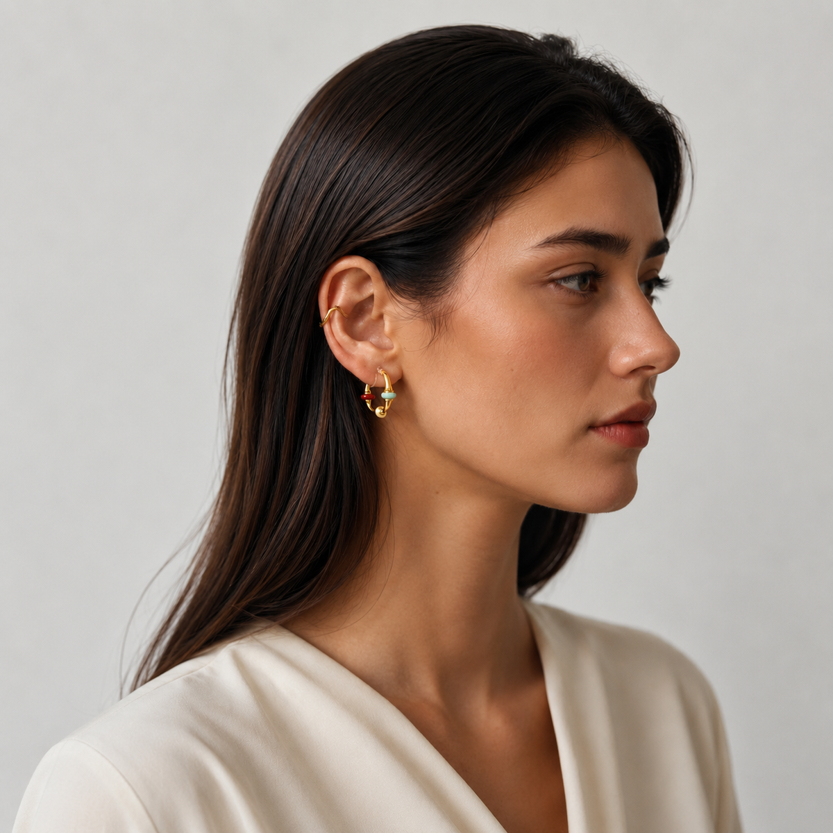 Model wearing a gold multicolor enamel clip-on hoop earring
