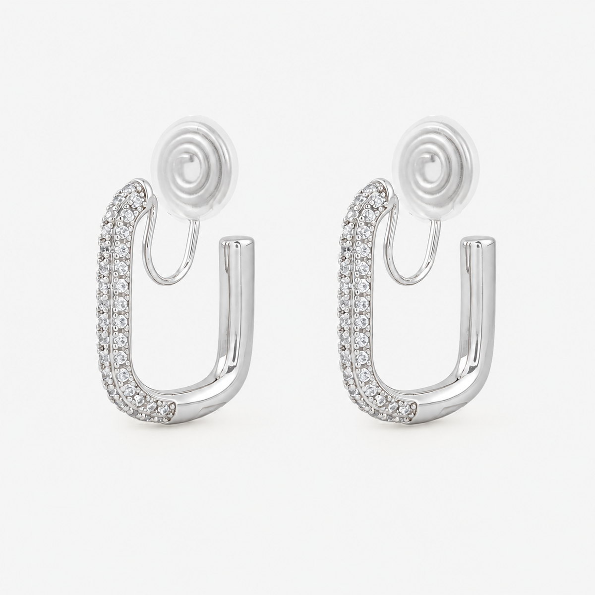 Silver pavé rectangle clip-on hoop earrings with rounded corners and cushioned coil backs, angled view