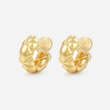 Gold quilted dome clip-on hoop earrings with polished raised sections and cushioned coil backs, angled view