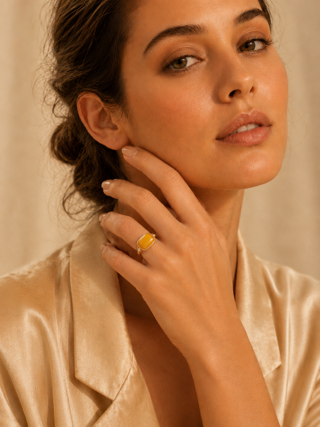 Model wearing the Sparkling Frame amber ring with a champagne satin blouse