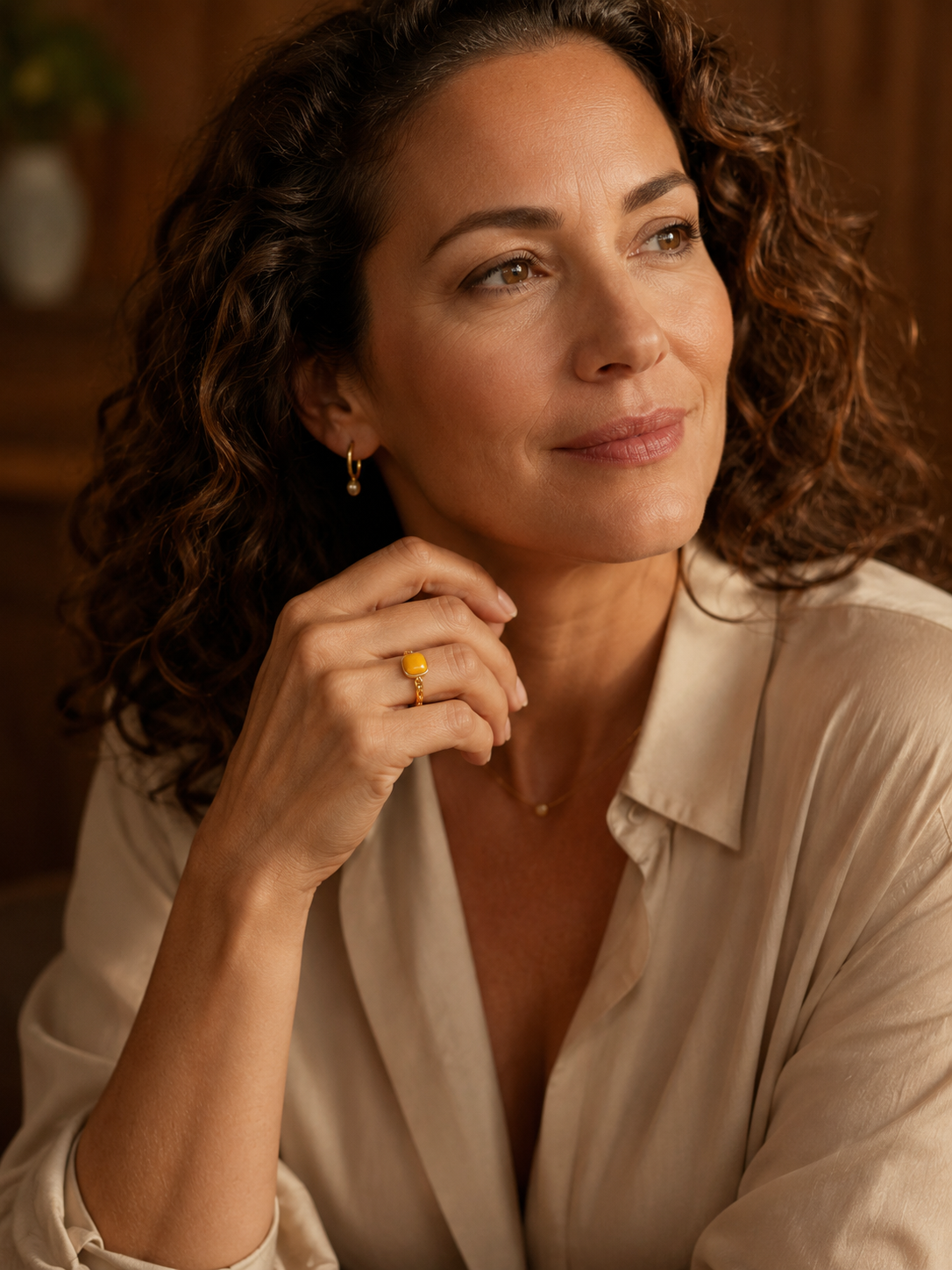 Model wearing the Linked Heritage amber ring with an ivory satin blouse