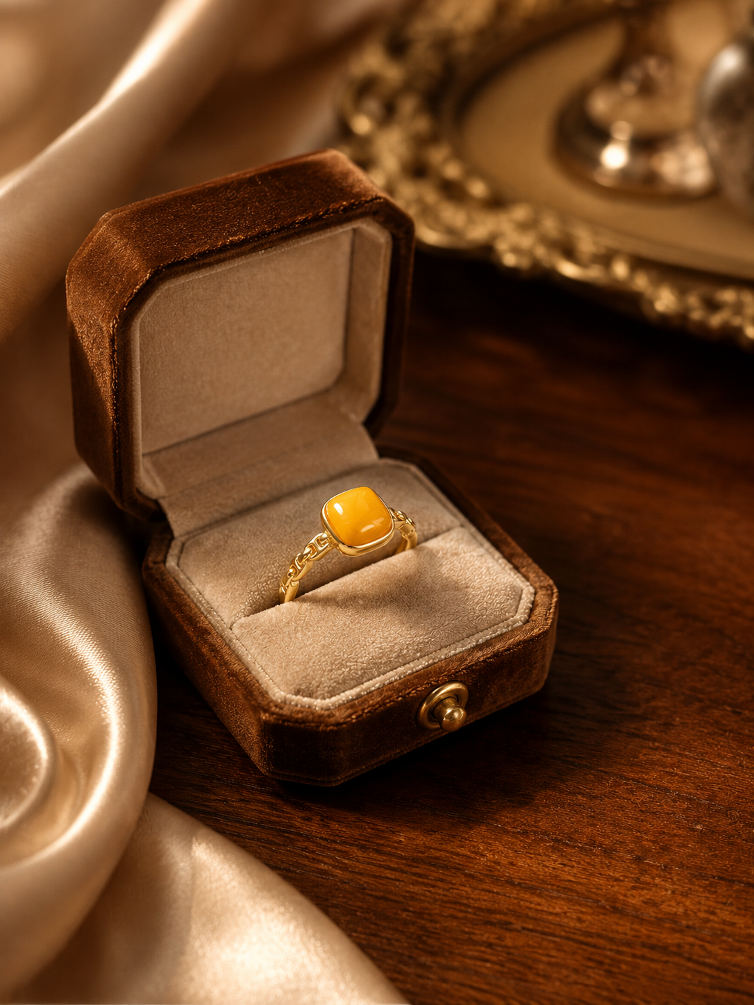 Linked Heritage amber ring displayed in a vintage brown jewelry box