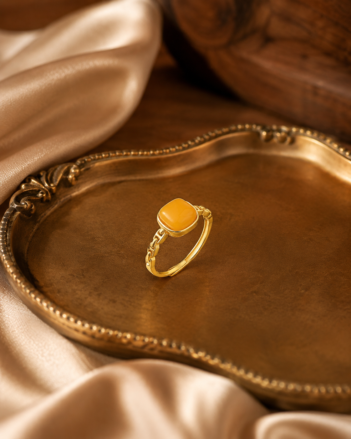 Linked Heritage amber ring centered on an antique gold tray with satin