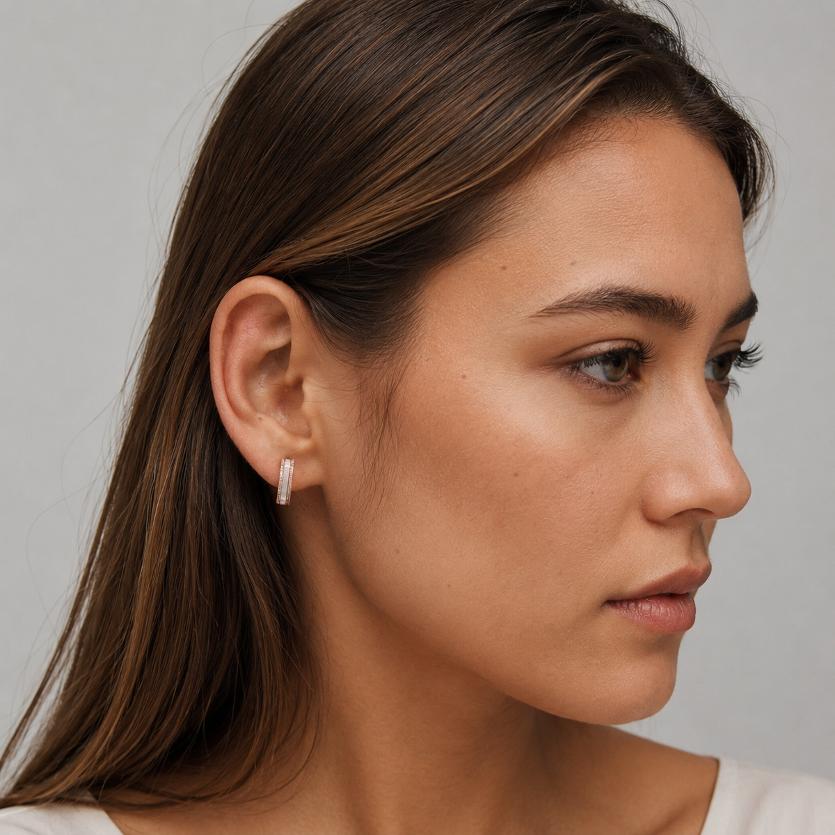 Model wearing a petite rose gold mother-of-pearl clip-on hoop earring