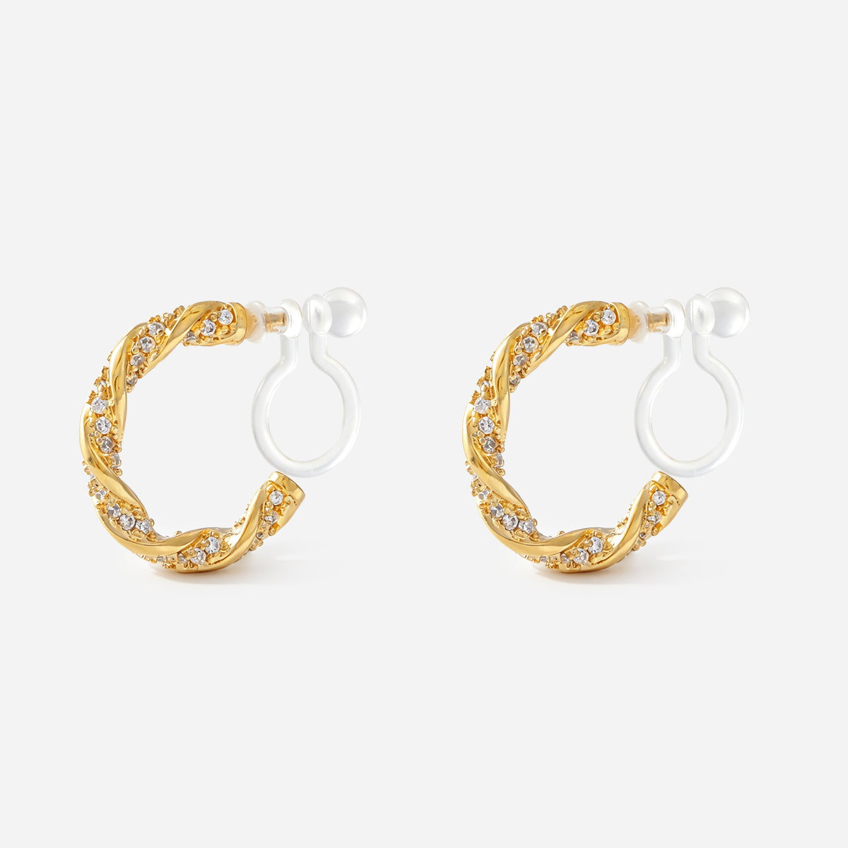 Angled view of SOMIY Pavé Twist Clip-On Hoop Earrings in gold, showing the clear resin clips