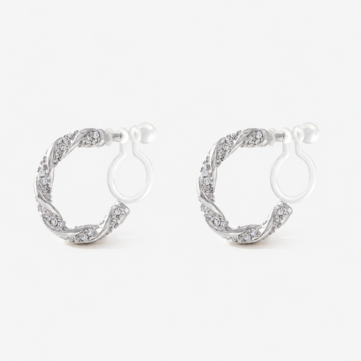 Angled view of SOMIY Pavé Twist Clip-On Hoop Earrings in silver, showing the clear resin clips
